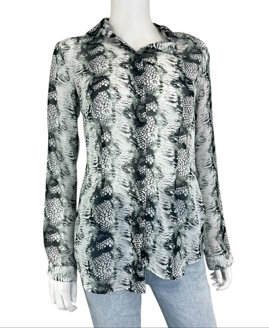 A black and white sheer button-down long sleeve shirt on a mannequin paired with blue jeans.